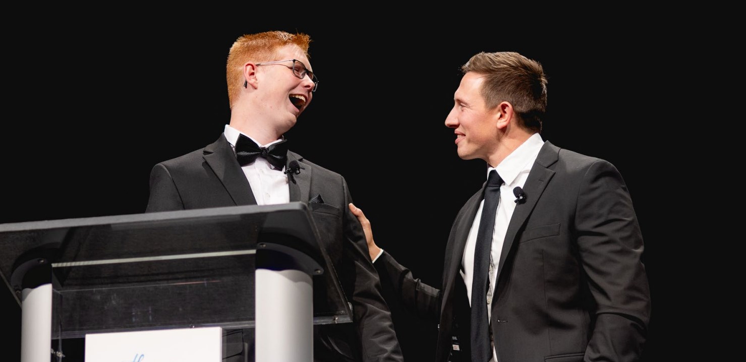 Two men laughing together on stage at a Mary Free Bed Foundation event
