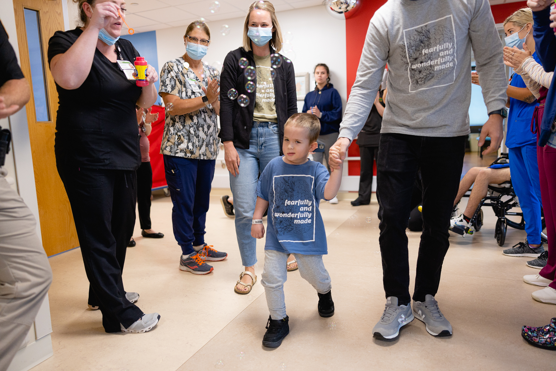 Jack walking down a hallway as his care team cheers him on