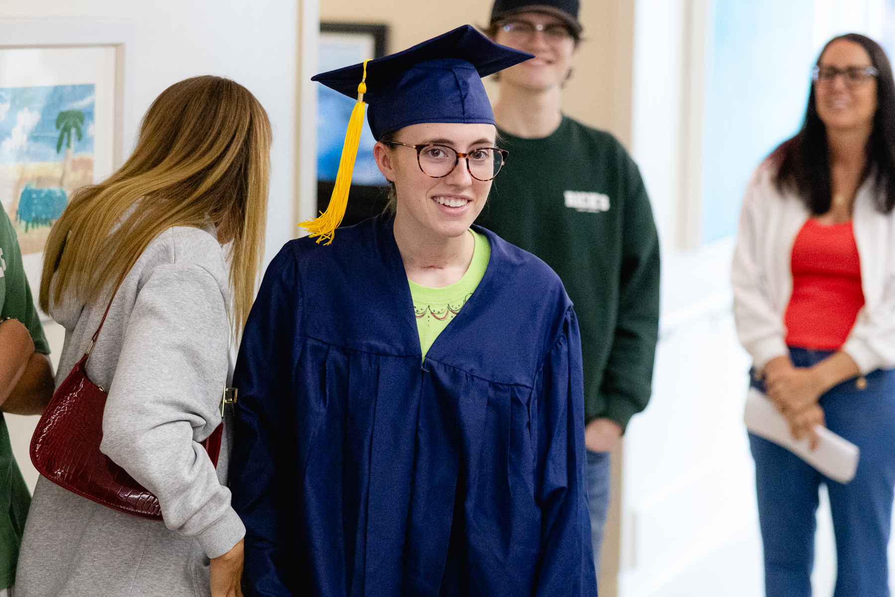 Madeline in a cap and gown at her therapy graduation