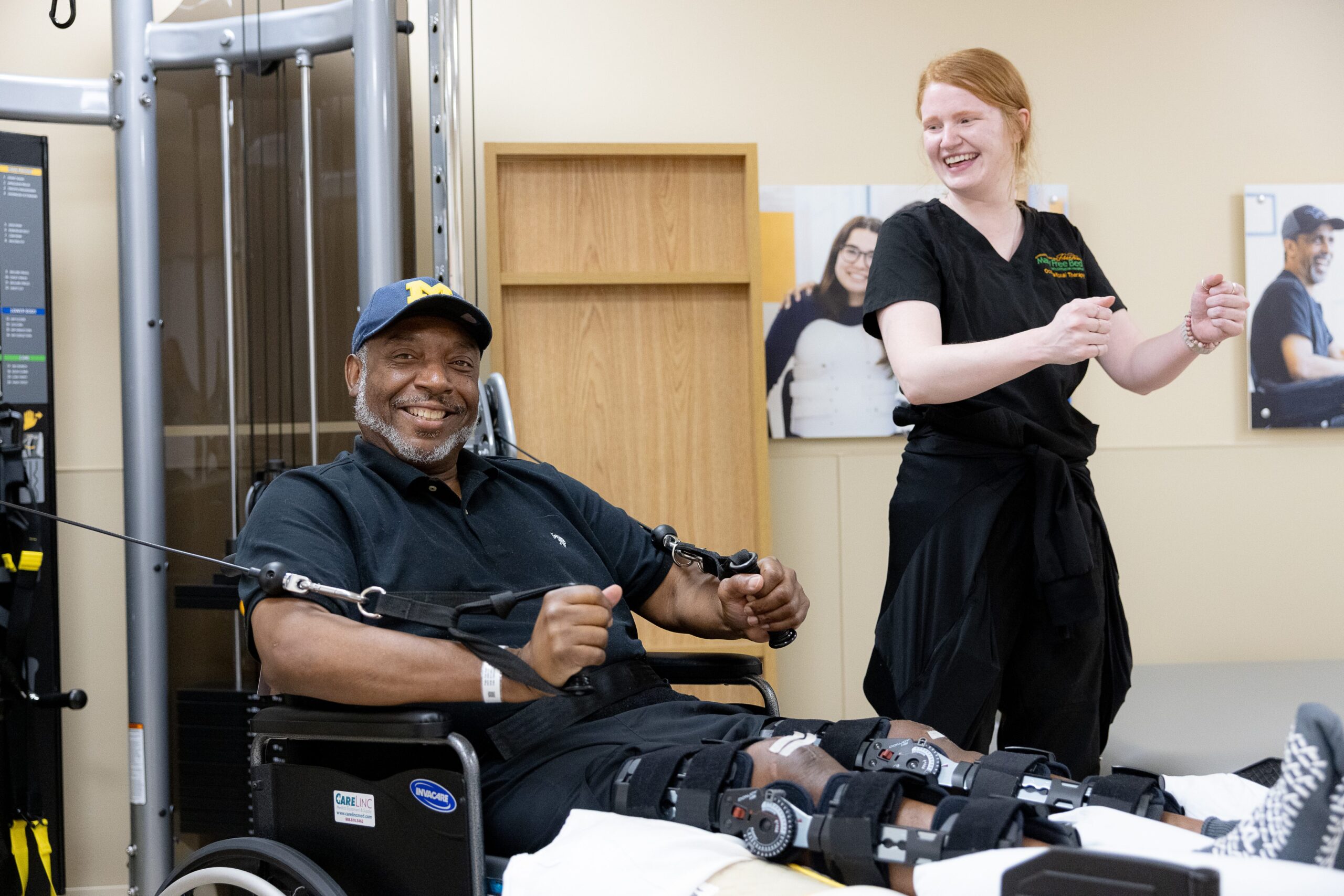 A Mary Free Bed therapist cheers on a smiling patient during an exercise session