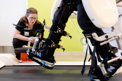 Therapist adjusting lokomat machine for cerebral palsy patient