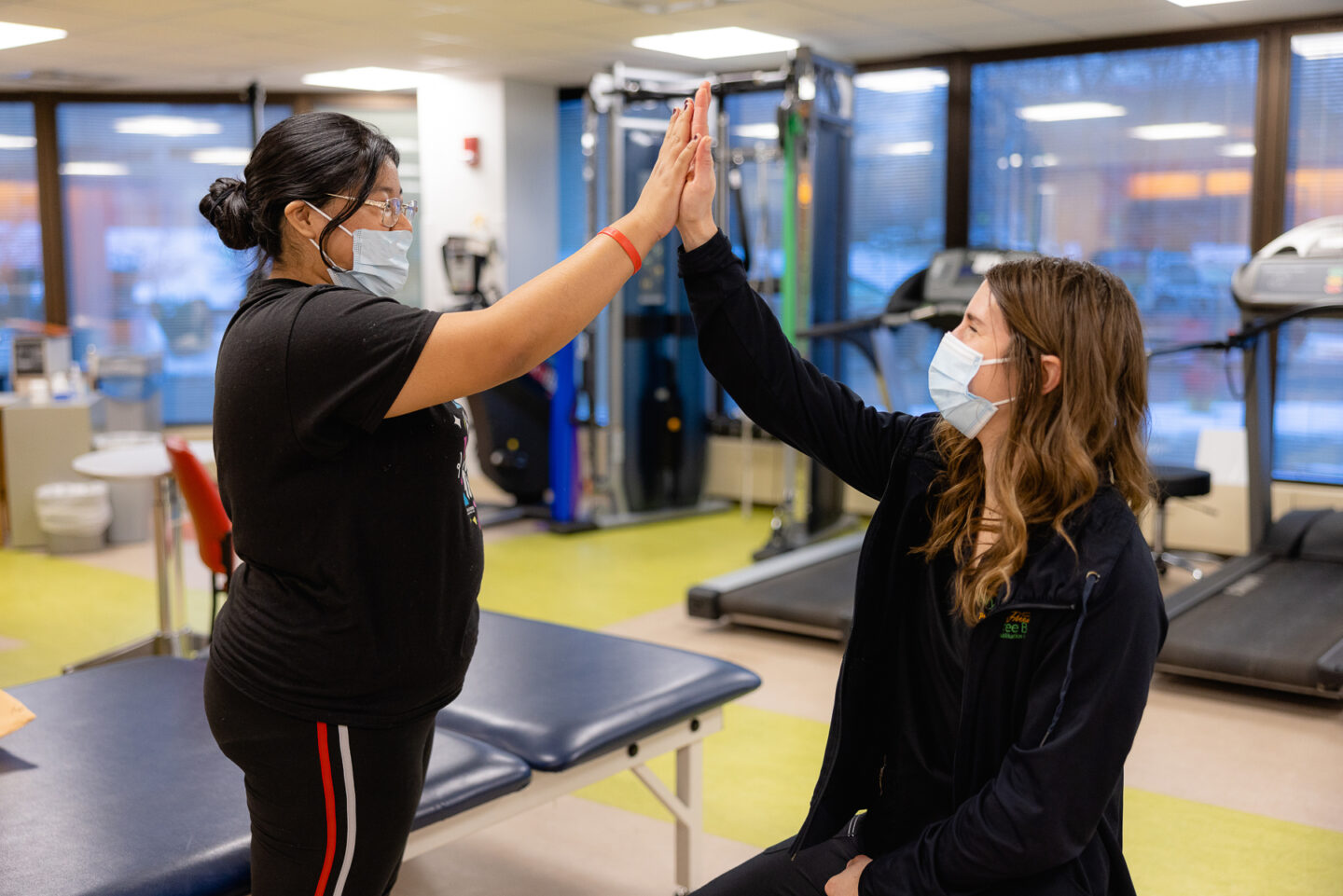 Pain outpatient room with a patient and specialist high fiving