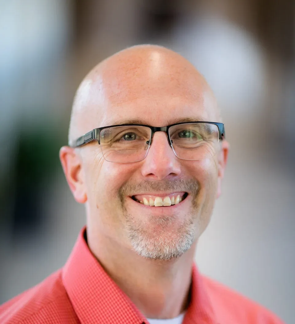 Smiling Mary Free Bed pediatric rehabilitation specialist wearing glasses and a red shirt in a professional headshot