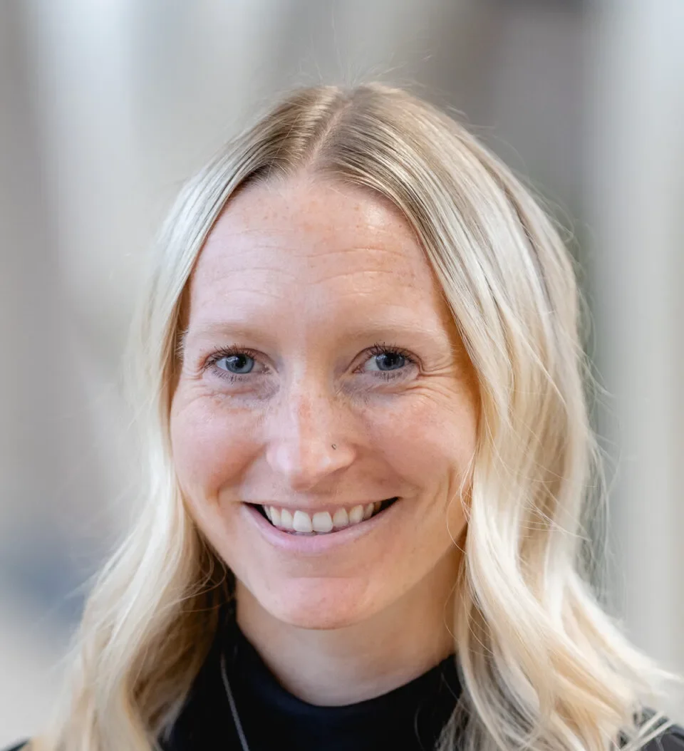 Smiling Mary Free Bed pediatric staff member with long blonde hair wearing a black turtleneck