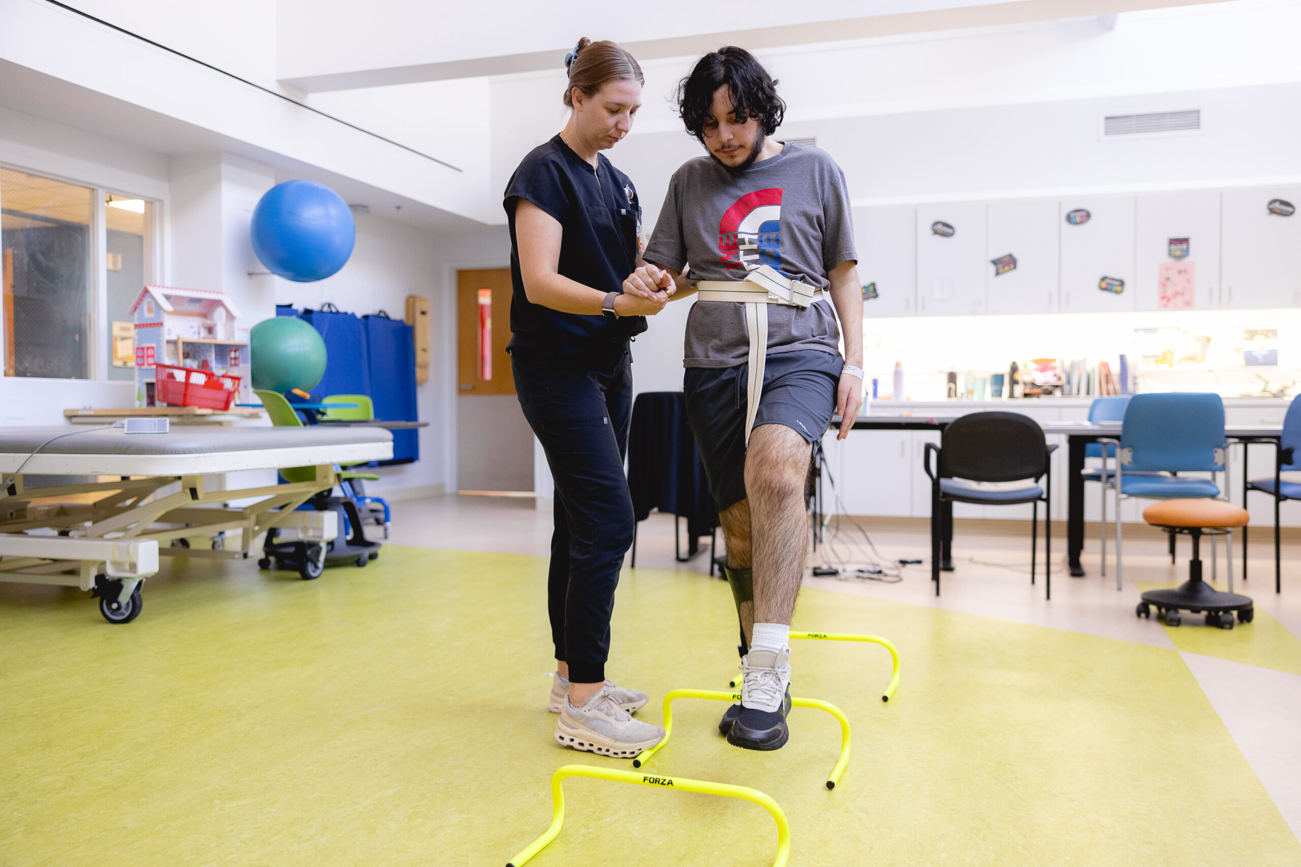 A spinal cord injury patient working on mobility with a physical therapist.