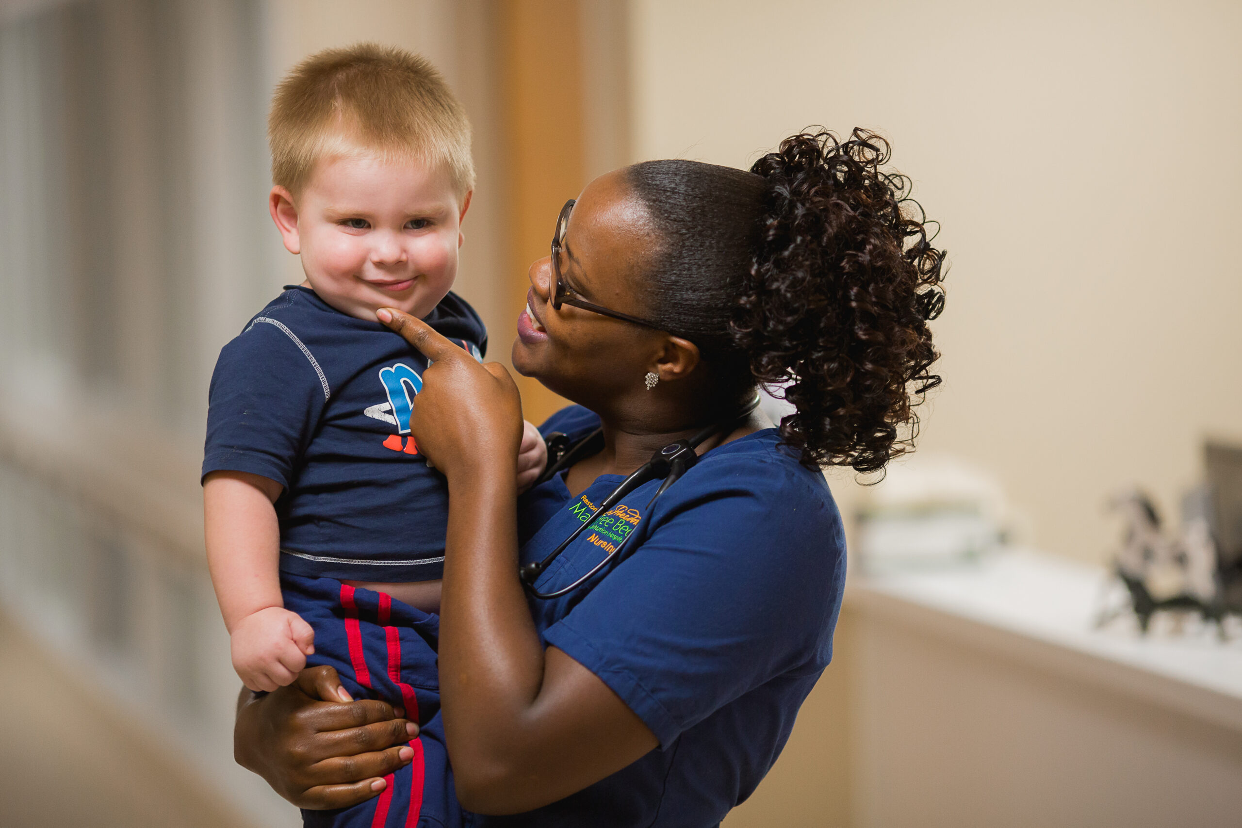 A registered nurse holding a pediatric patient.