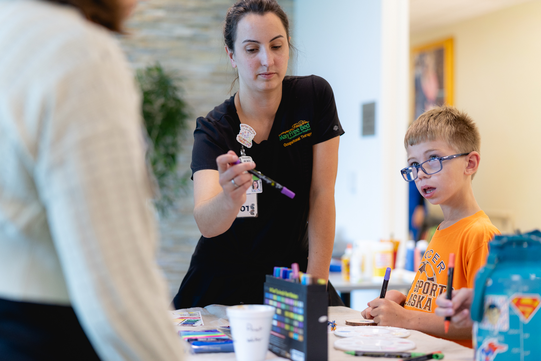 Pediatric art therapy patient helping to create leaves for the ArtPrize communitree project