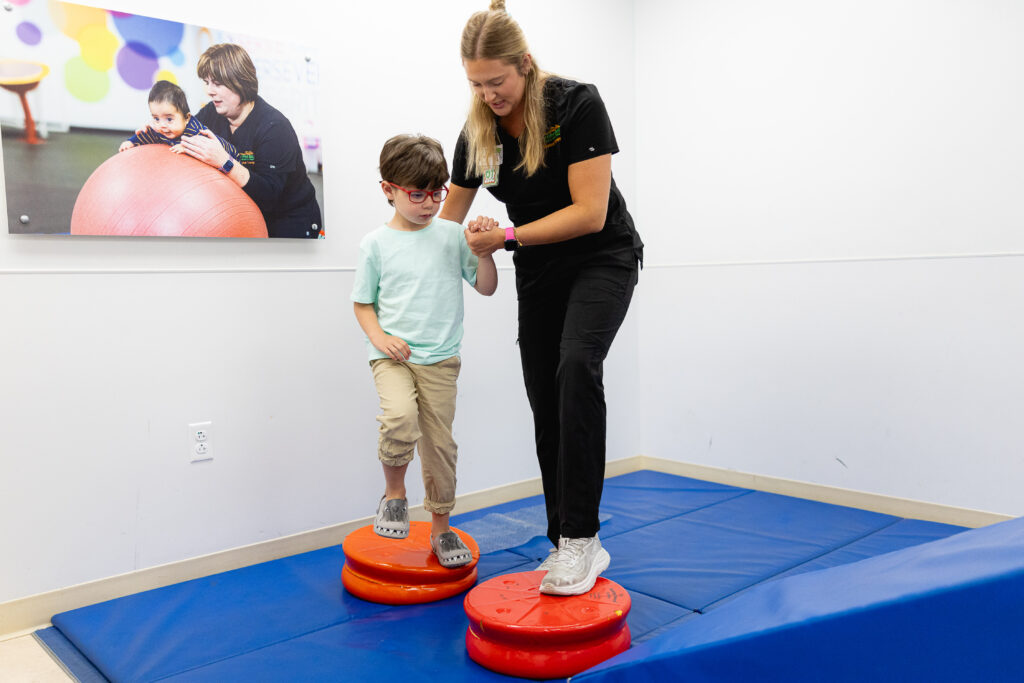 An occupational therapist helping a pediatric patient through a therapy exercise
