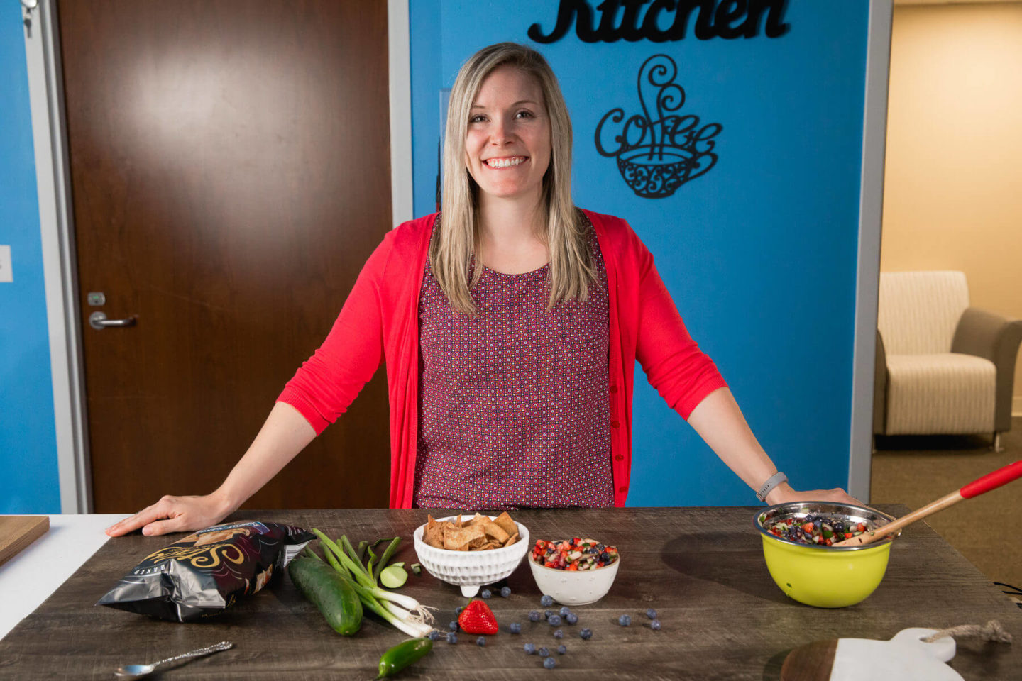 A smiling nutrition expert at Mary Free Bed demonstrates a healthy fruit salsa recipe in a kitchen setting.