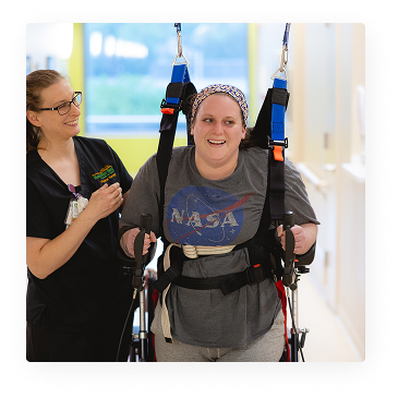 Brain Injury 44 patient walking down hallway assisted by harness