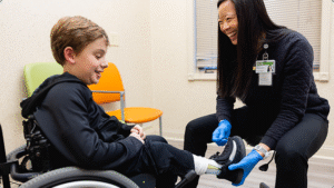 Child patient dealing with amputation being helped by a professional at Mary Free Bed.