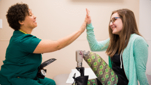 Amputee patient and amputation specialist high fiving.