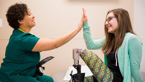 Amputee patient and amputation specialist high fiving.