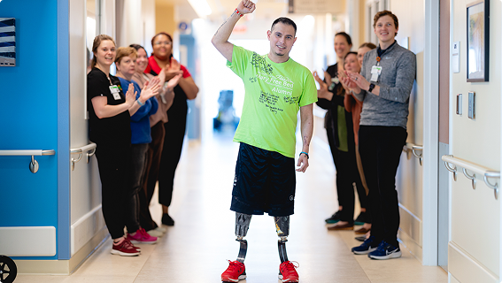 Patient at Mary Free Bed being cheered on by hospital staff.
