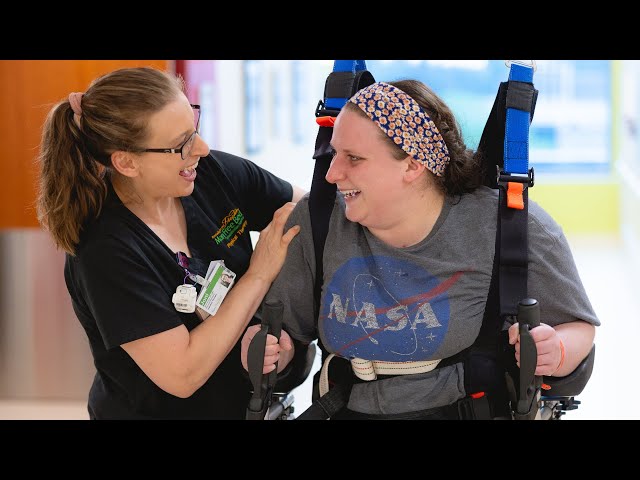 patient walking with assistive device with the help of a physical therapist
