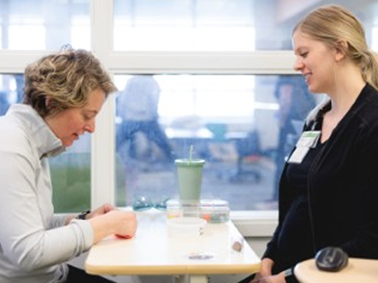 Specialist helps a patient with hand therapy.