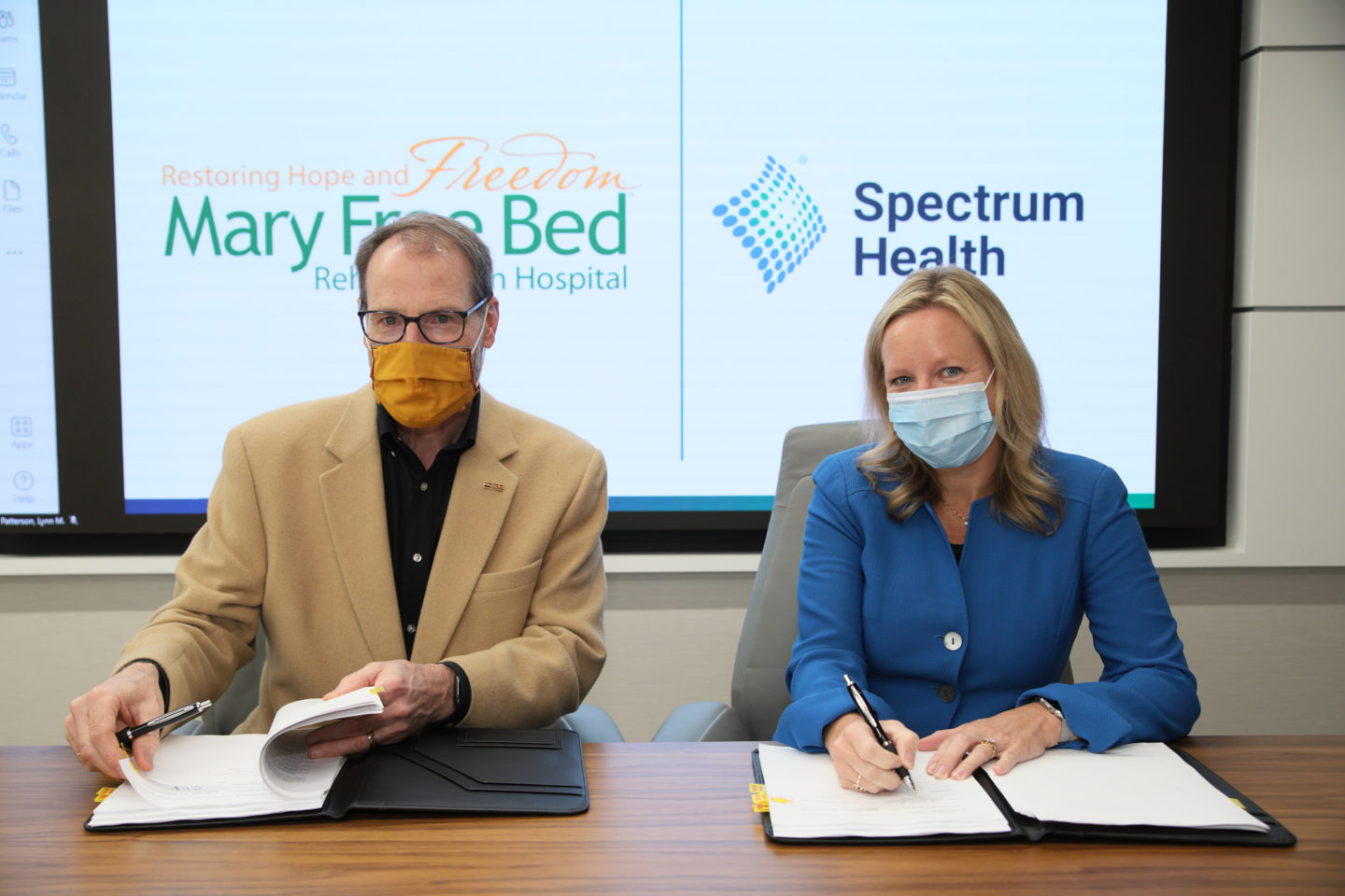 Mary Free Bed CEO Kent Riddle and Spectrum Health President & CEO Tina Freese Decker sign new collaboration agreement for acute pediatric rehabilitation