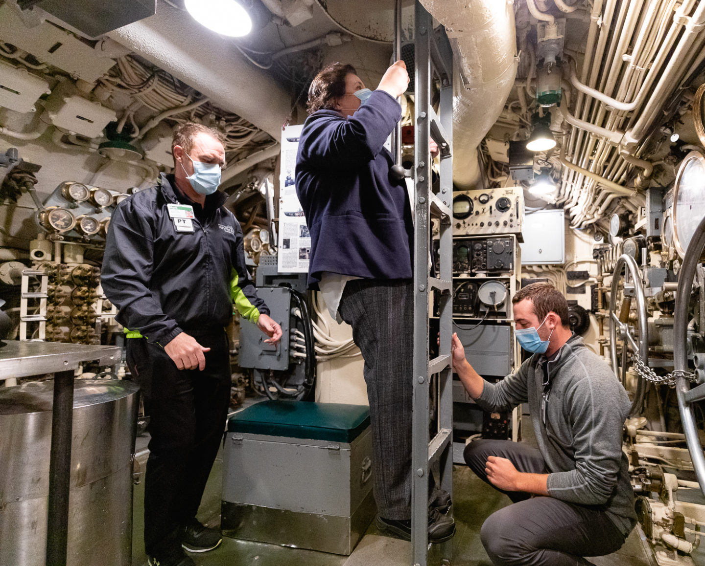 Peggy Maniates climbs ladder inside USS Silversides submarine