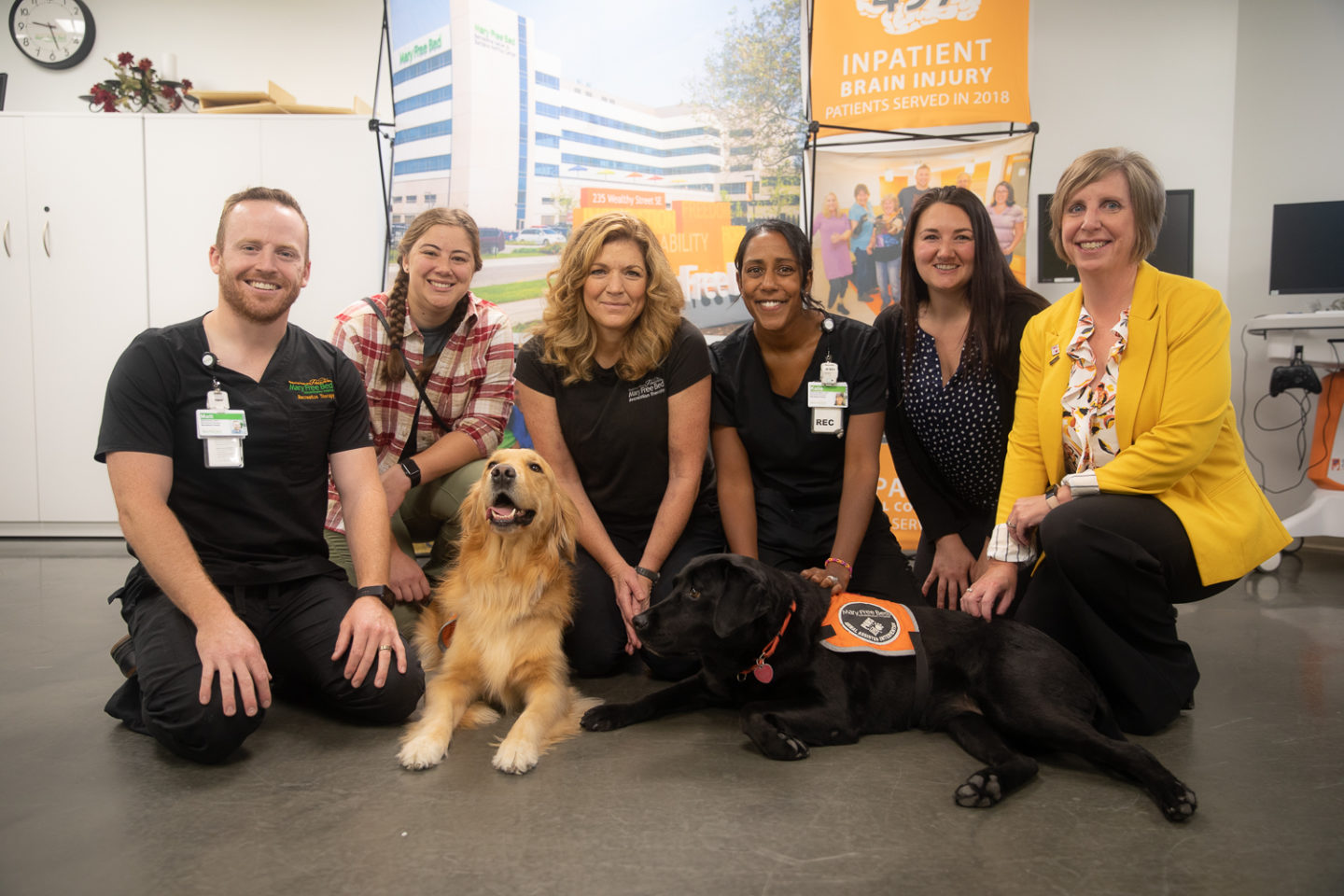 Recreational therapy team at Mary Free Bed smile with animal-assisted therapy dogs from Paws with a Cause