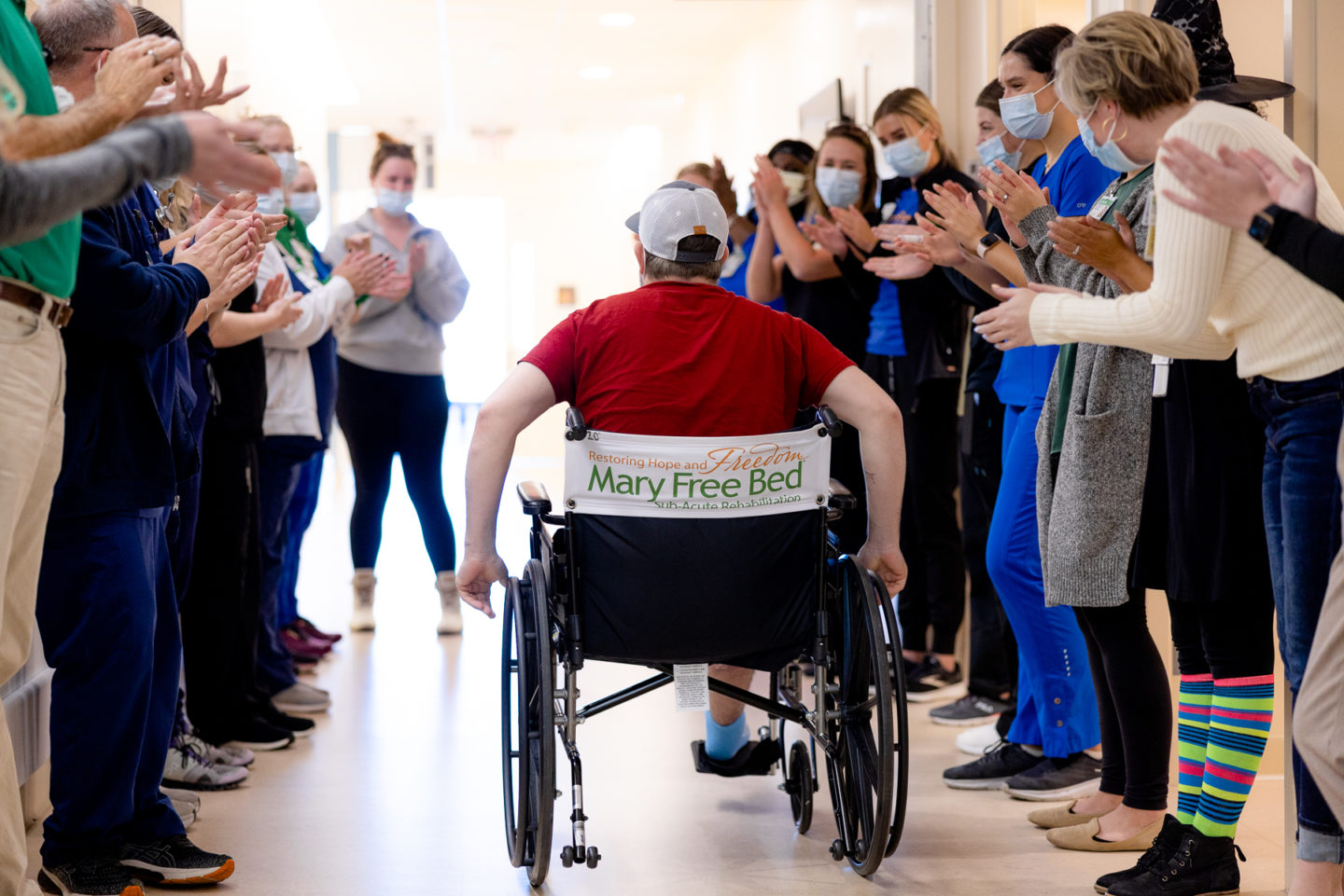 Patient graduates from Mary Free Bed Sub-Acute Rehabilitation Program with staff cheering them as they return home.