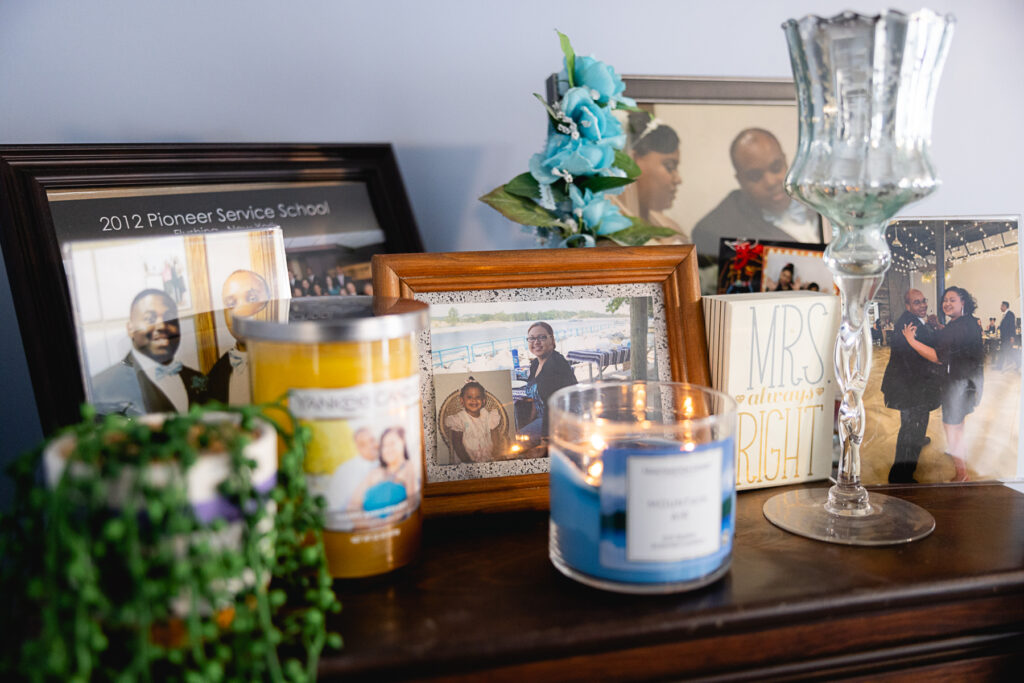 A shelf in Lavell's home filled with framed family photographs and candles.