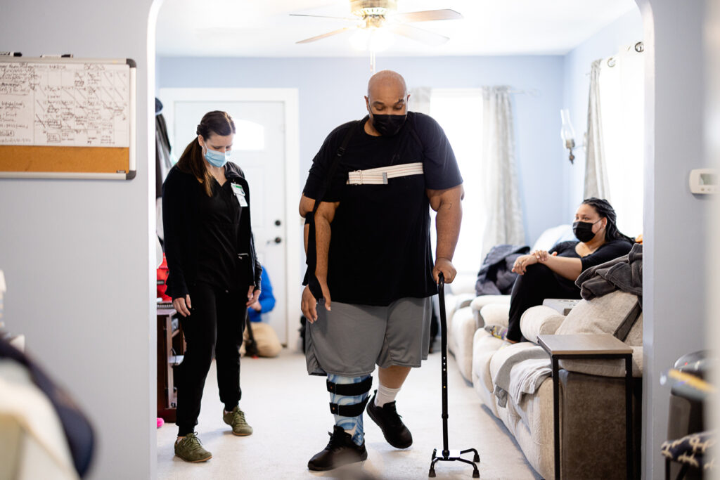 Lavell and his therapist practice taking steps at home.
