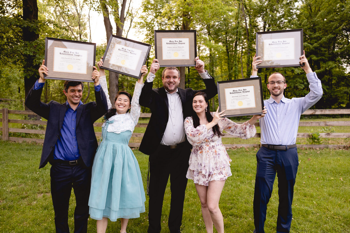 Five Mary Free Bed graduating residents proudly display their diplomas.