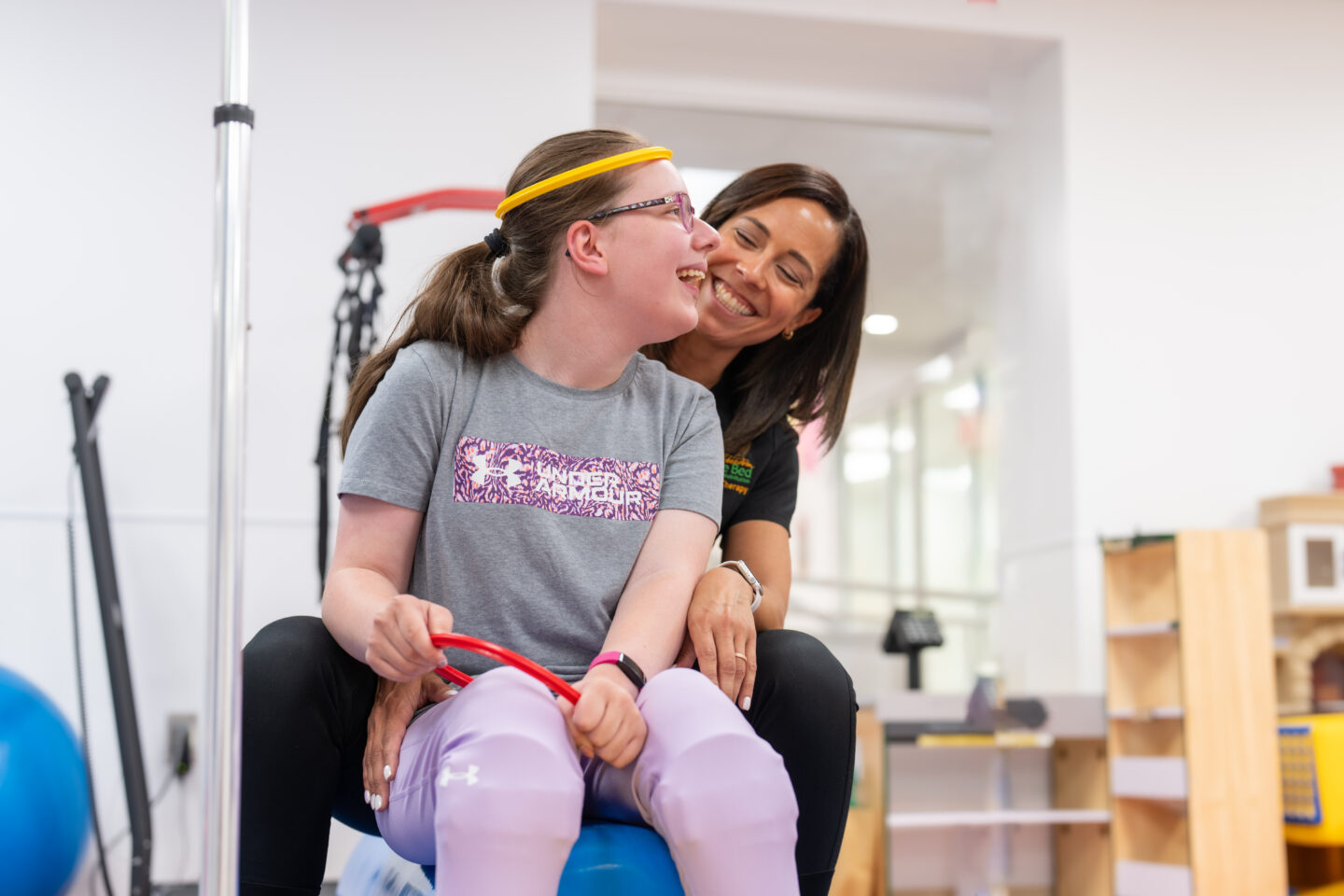 Loralei smiles at physical therapist during a therapy session with her physical therapist