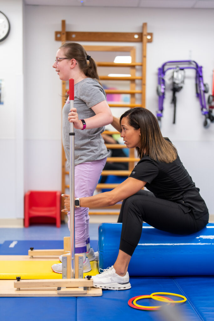 Loralei works on standing straight with her physical therapist at Mary Free Bed Rehabilitation Hospital