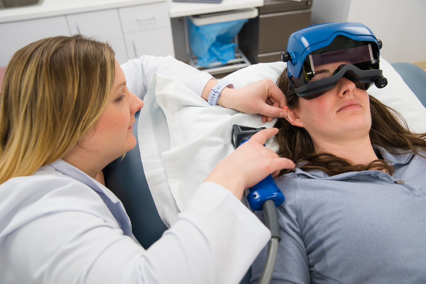An audiologist uses technology during an evaluation.