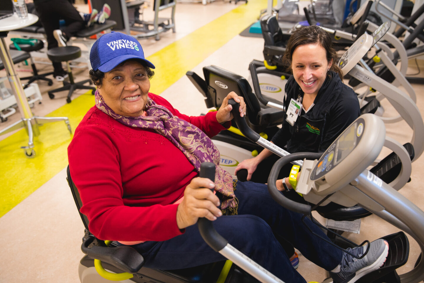 A patient using a recumbent bike during an appointment with a physical therapist at Mary Free Bed.