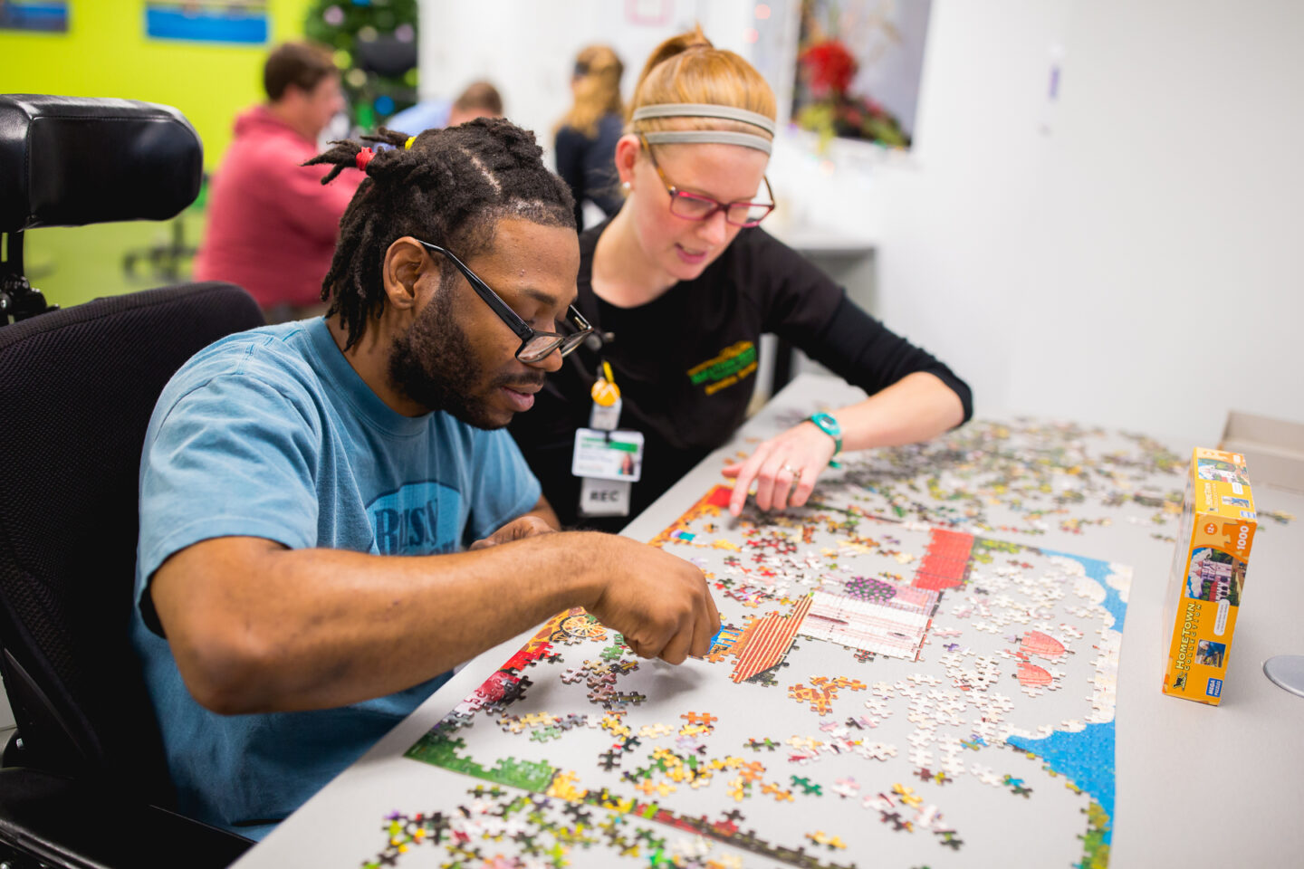 A patient works on a large puzzle with a recreational therapist, focusing on cognitive and social skills during a therapy session.