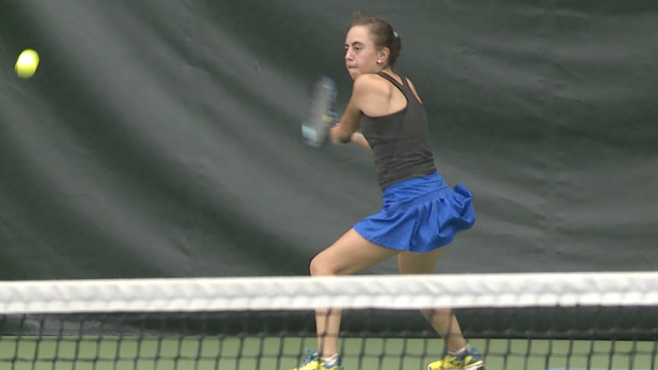 In The Media 25 Female player hits ball in the tennis championship.