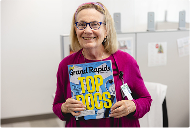 person holding grand rapids top dogs magazine
