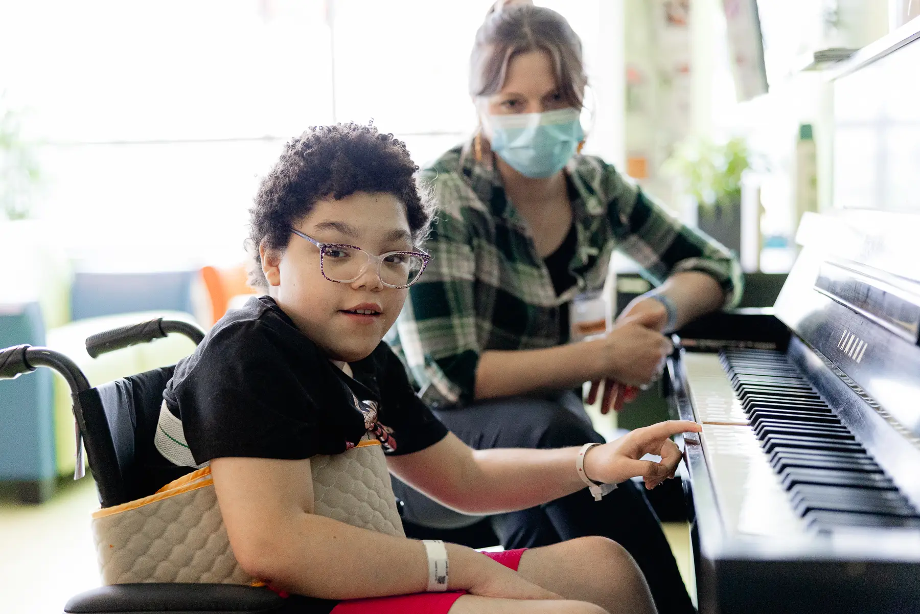 Mary Free Bed pediatric music therapy patient playing the piano