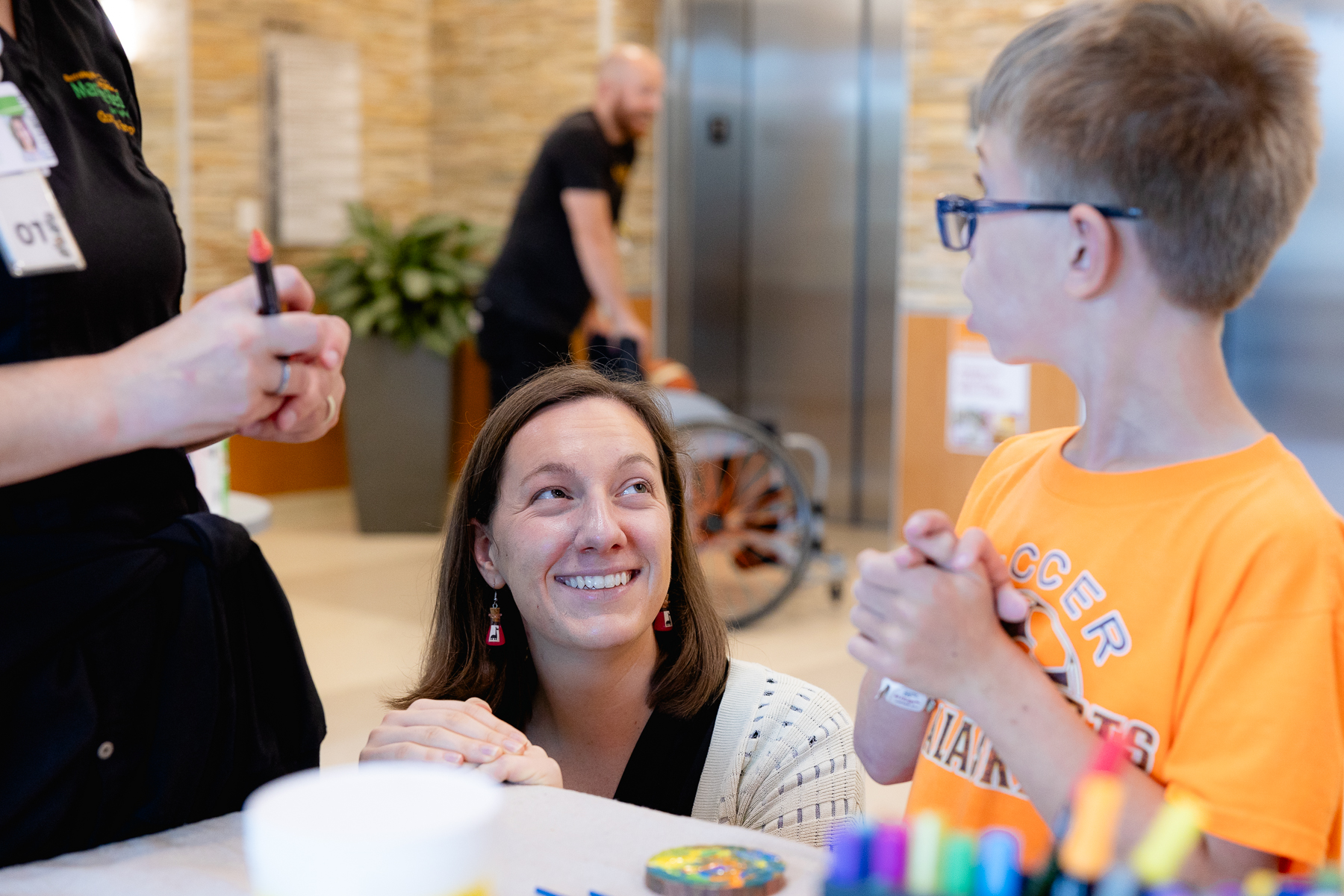 Pediatric art therapy patient helping to create leaves for the ArtPrize communitree project
