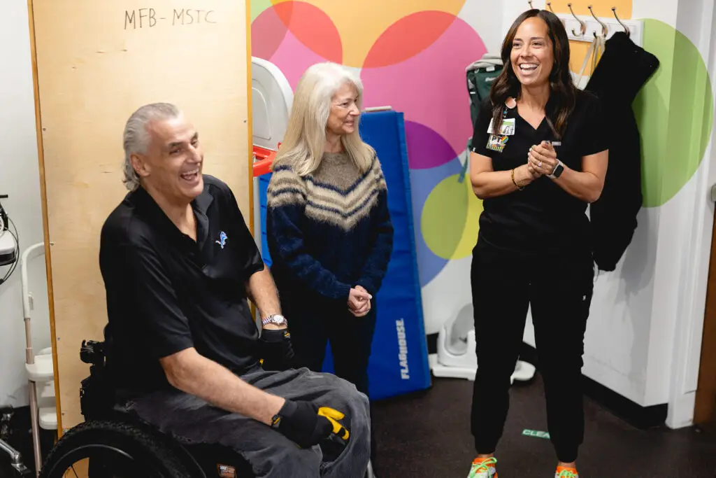 Mike Utley shown laughing with Mary Free Bed Therapists